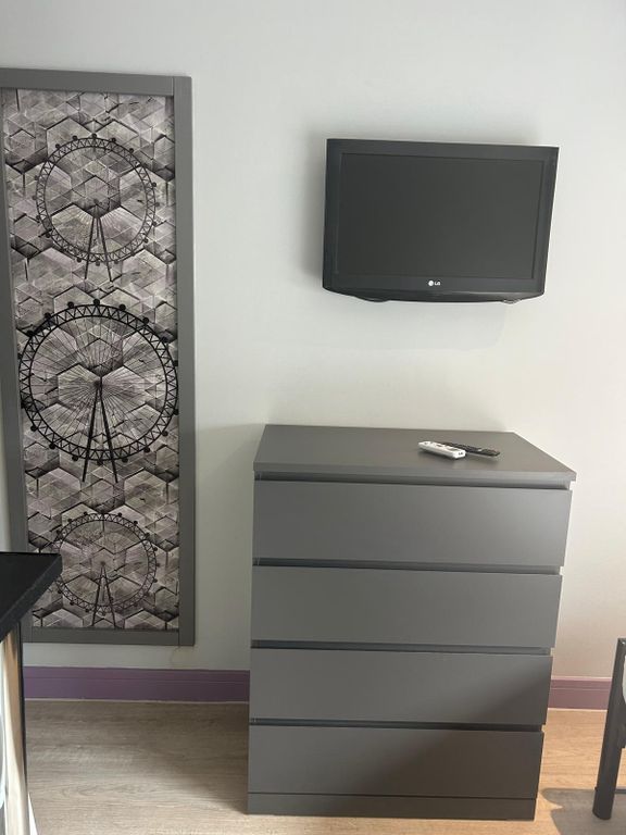 Property photo 2 of 5 Neutral-Toned Bedroom Corner With A Modern Grey ch...