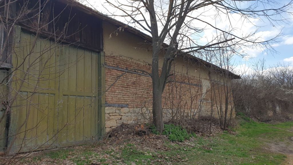 Property photo 3 of 53 Side View Of A Brick Building With A Large Green Wooden Door And Leafless Branches