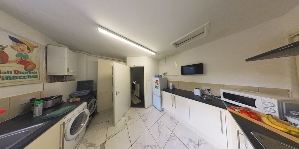 Property photo 3 of 7 Bright And Modern Kitchen Featuring Sleek White Ca...
