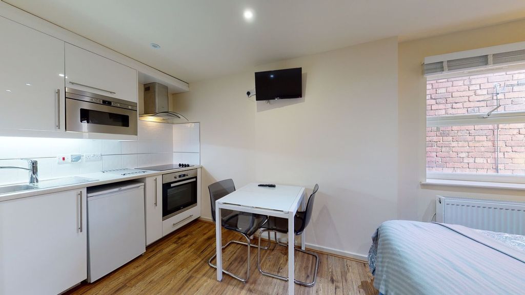 Property photo 3 of 8 A Modern, Compact Kitchen Featuring Sleek White Ca...