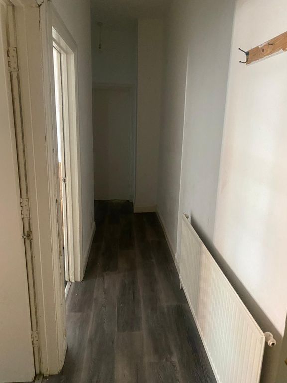 Property photo 3 of 6 A Narrow Hallway Featuring Clean Wooden Flooring A...