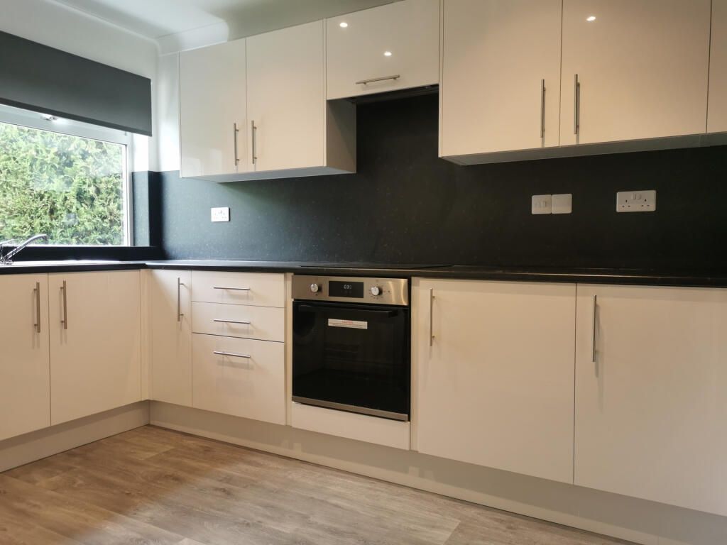 Property photo 2 of 12 Modern White Kitchen With Sleek Black Splashback...