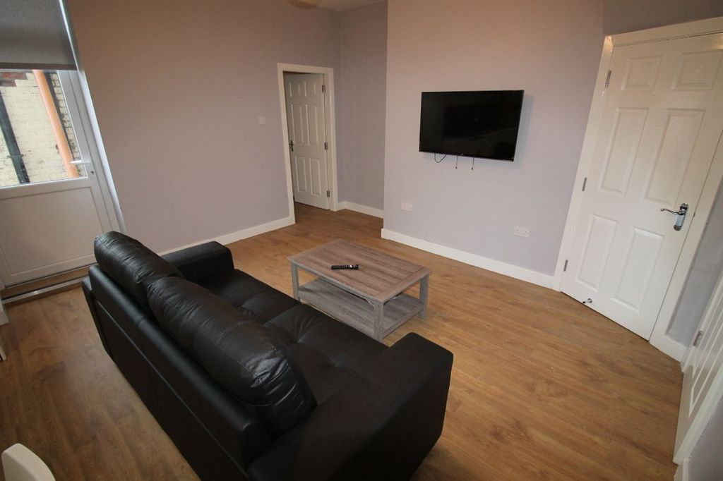 Property photo 2 of 11 A Cozy Living Room Featuring A Stylish Black Sofa,...