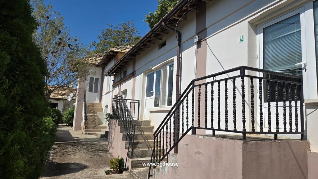 Property photo 1 of 100 White Building With Beige Stripes, Concrete Stairs, Black Metal Railings, And Surrounding Greenery Under Blue Sky.