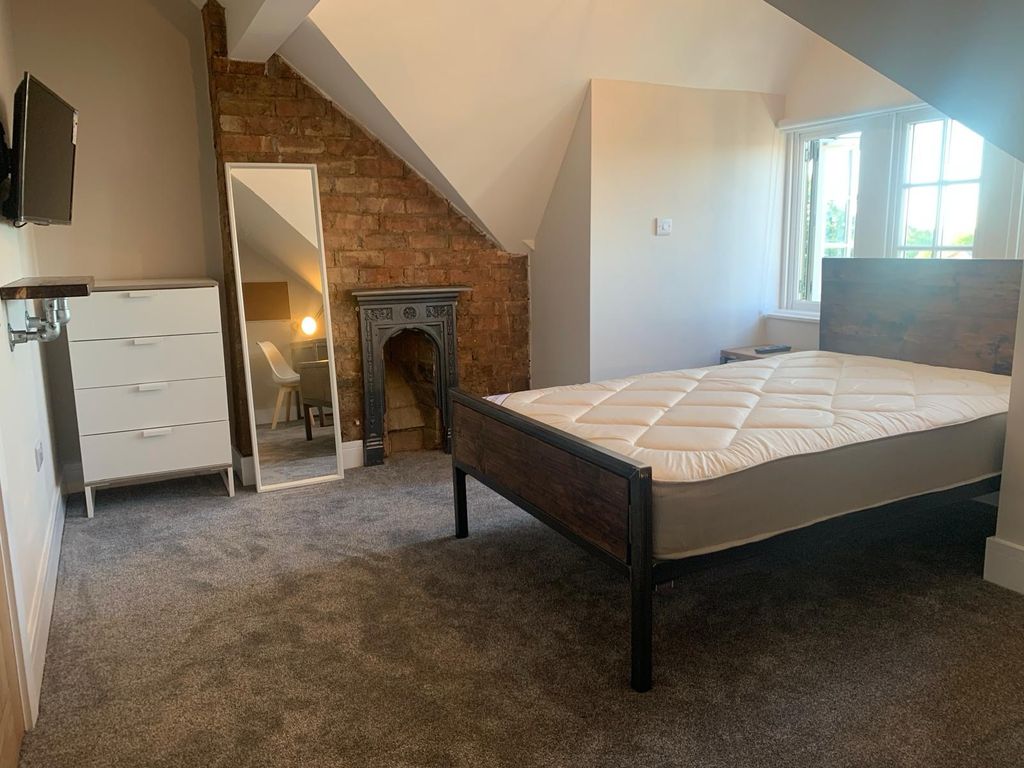 Property photo 1 of 7 Spacious And Well-Lit Bedroom Featuring A Sturdy d...