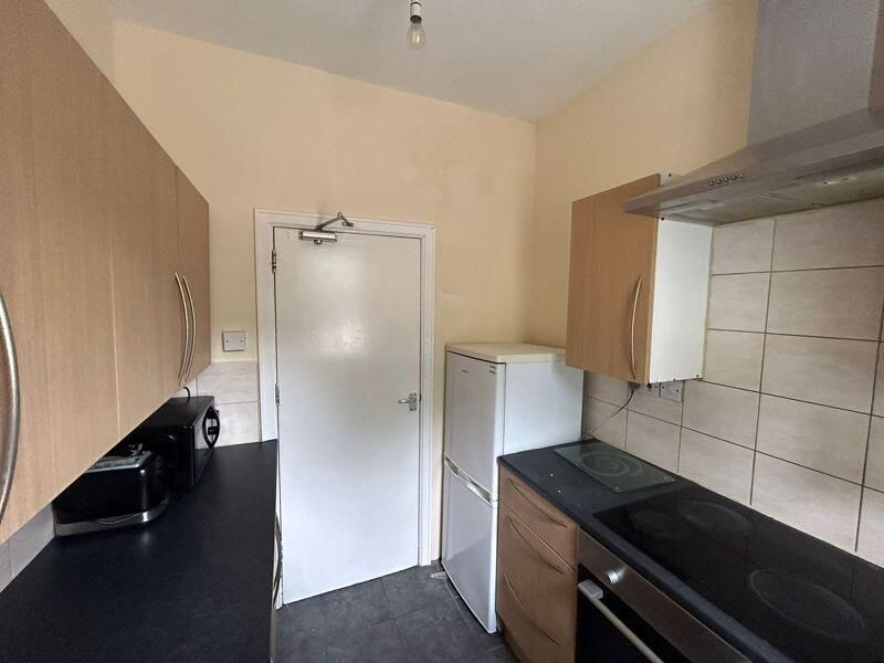 Property photo 3 of 9 A Modern Kitchen Featuring Wooden Cabinetry, A Bla...