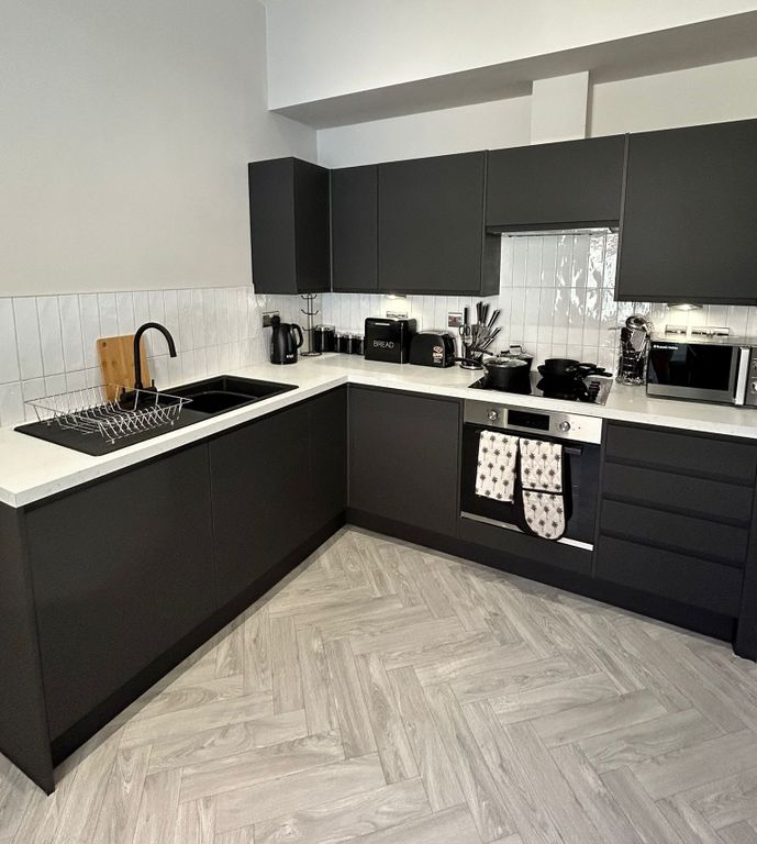 Property photo 2 of 7 Modern Kitchen With Sleek Black Cabinets, Clean Wh...