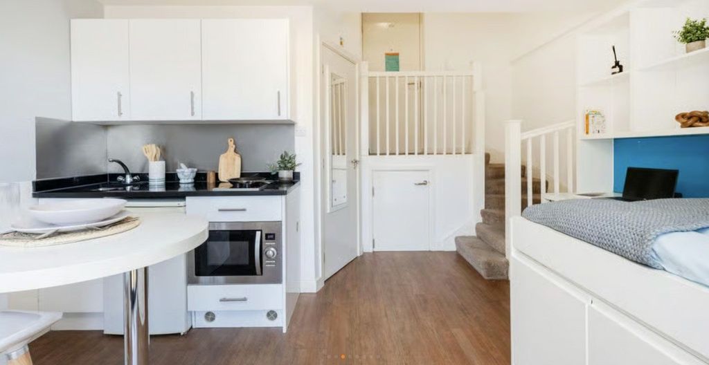 Property photo 2 of 6 Modern Studio Kitchen With Sleek White Cabinets....