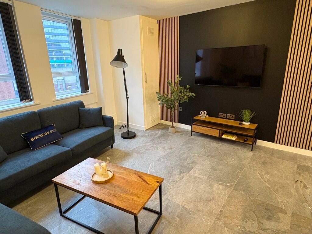 Property photo 3 of 15 A Modern Living Room Featuring A Comfortable Dark ...