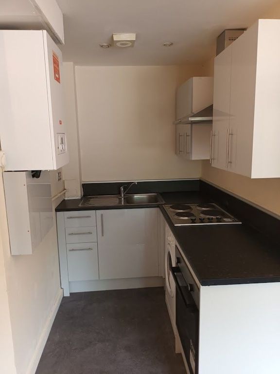 Property photo 2 of 7 Modern White Kitchen With Sleek Black Countertops...