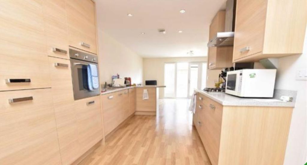 Property photo 3 of 9 A Modern Kitchen Featuring Light Wood Cabinetry An...