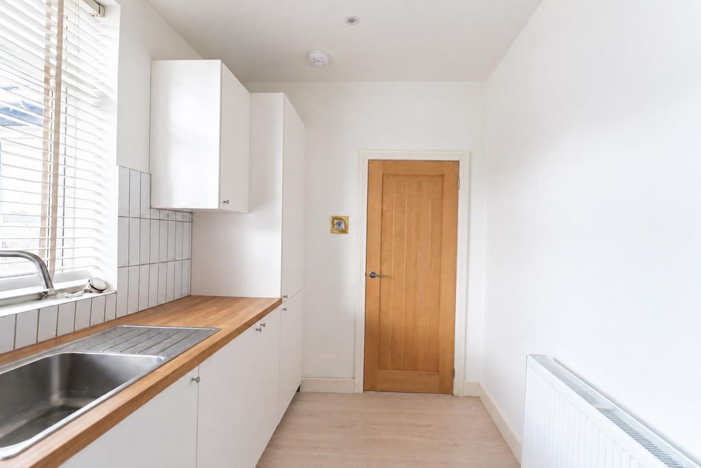Property photo 3 of 10 Minimalist White Kitchen With Wood Accents.Png
