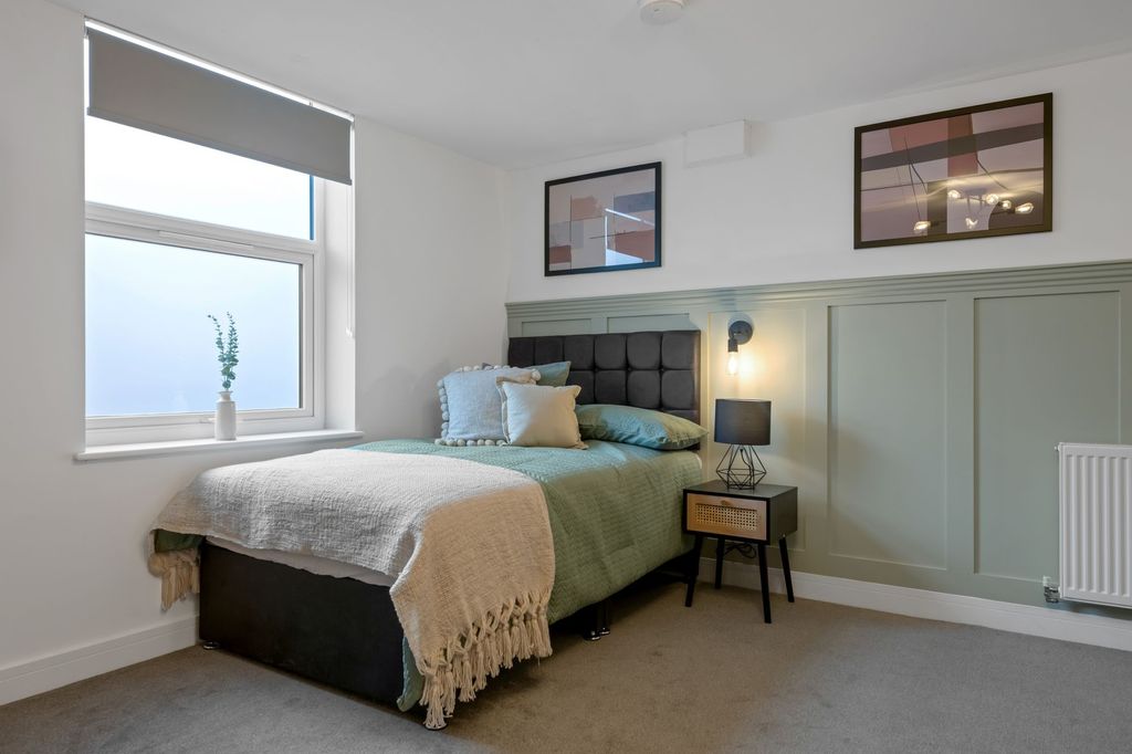 Property photo 2 of 7 A Spacious And Well-Lit Bedroom Featuring A Large ...