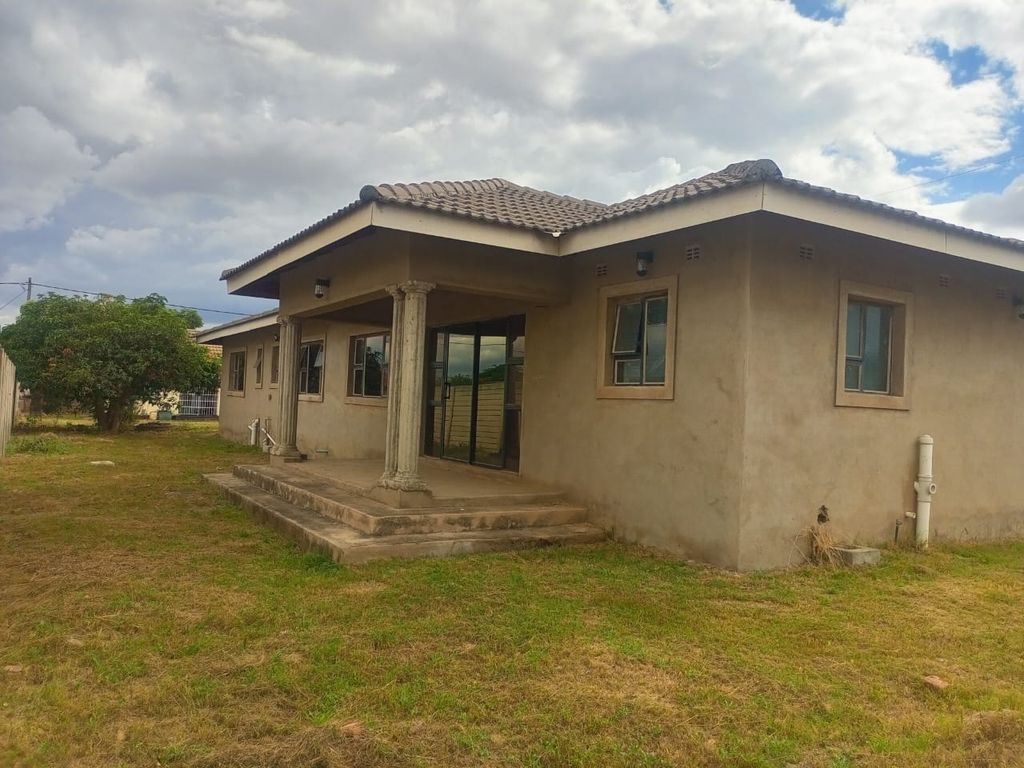 Property photo 3 of 11 Single-Story Beige Stucco House With A Small Covered Porch Supported By Two Columns And Sliding Glass Door, In A Grassy Yard Under Cloudy Sky.
