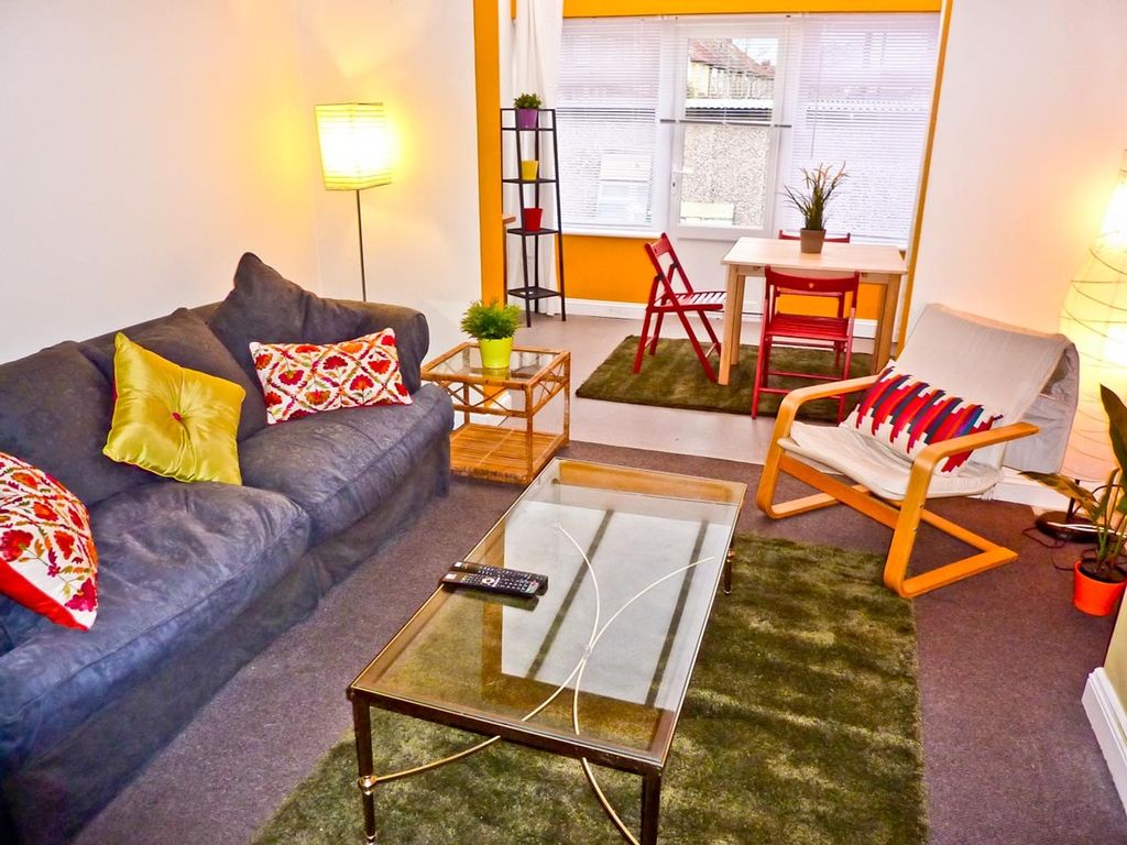 Property photo 2 of 6 A Vibrant Living Room Featuring A Cozy Couch Adorn...