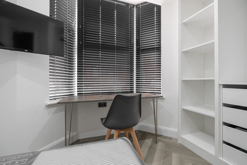 Property photo 1 of 11 A Well-Kept Bedroom Featuring A Desk Area With A W...