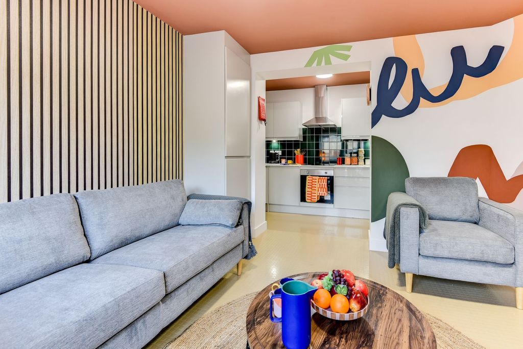 Property photo 2 of 6 A Vibrant And Cozy Living Room Featuring Modern Fu...