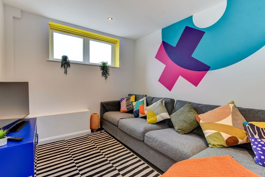 Property photo 1 of 7 A Vibrant Living Room Featuring A Cozy Gray Sofa A...