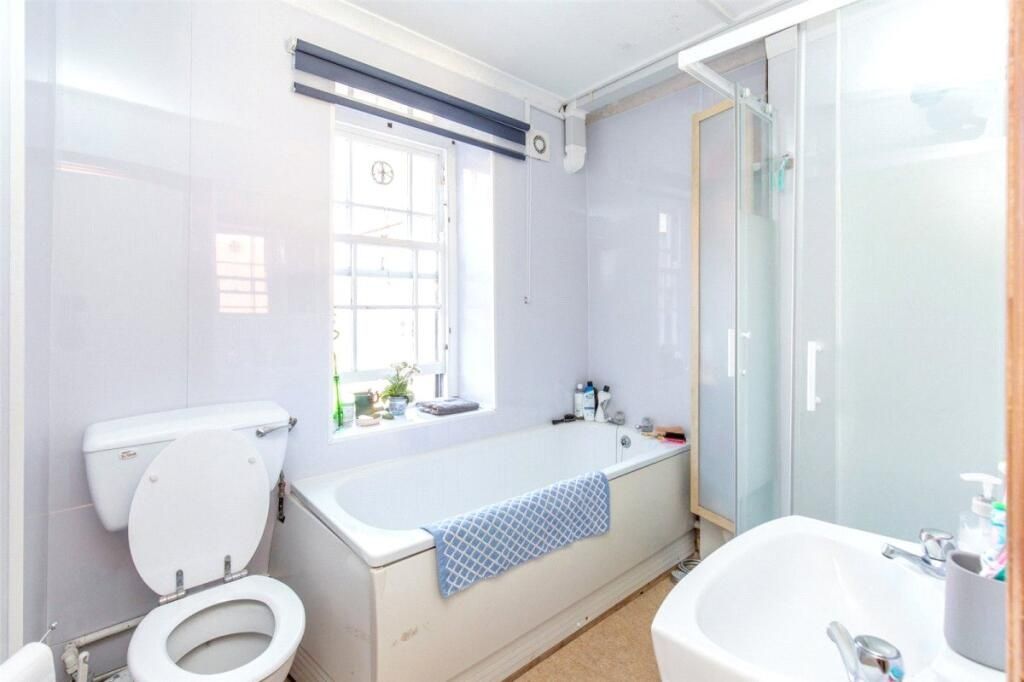 Property photo 3 of 7 A Clean, Well-Lit Bathroom Featuring A Bathtub Wit...