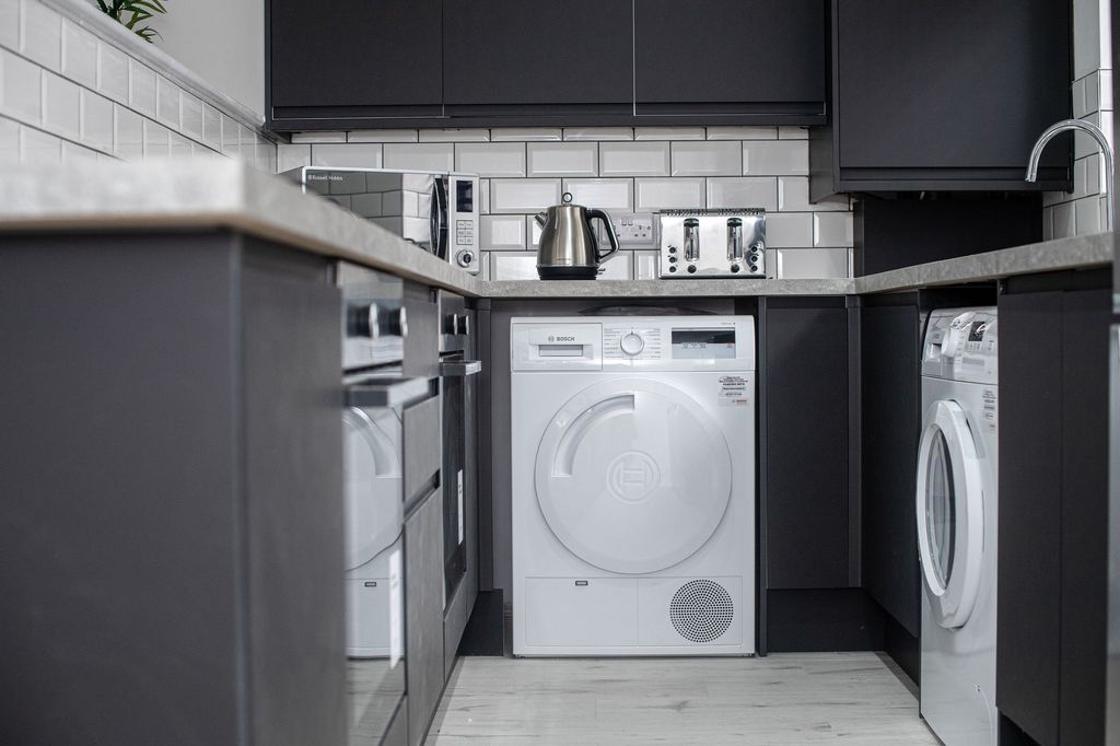 Property photo 3 of 9 Modern Kitchen Featuring Sleek Black Cabinets, Whi...