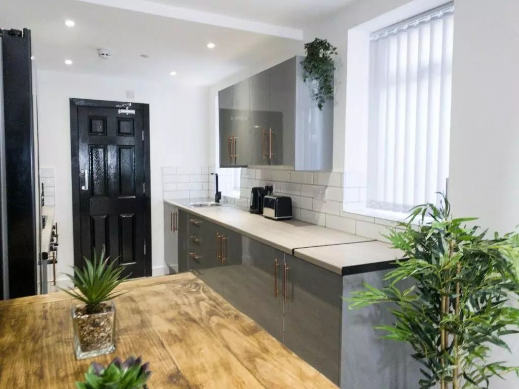 Property photo 2 of 9 A Modern Kitchen Featuring Sleek Grey Cabinets Wit...