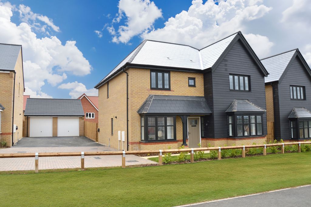 Property photo 1 of 10 A Modern Tan And Dark Gray House With A Double Garage Sits Behind A Neat Lawn And Wooden Fence
