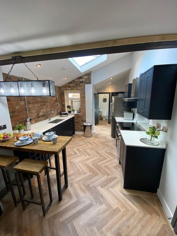 Property photo 3 of 6 Modern Kitchen Featuring Sleek Black Cabinets, Whi...