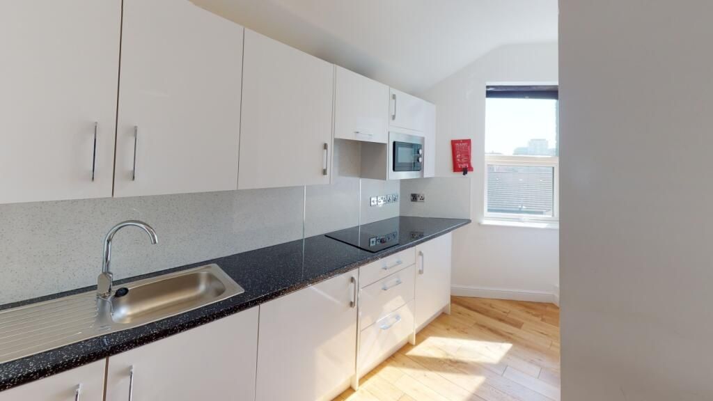 Property photo 3 of 8 Bright And Modern Kitchen Featuring Sleek White Ca...