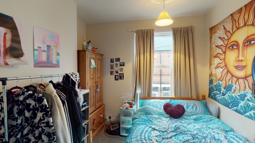 Property photo 2 of 7 A Cozy Bedroom With A Vibrant Sun-Themed Mural Abo...