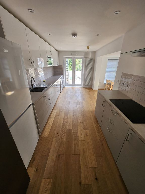 Property photo 1 of 19 Modern And Sleek Kitchen Featuring White Cabinetry...
