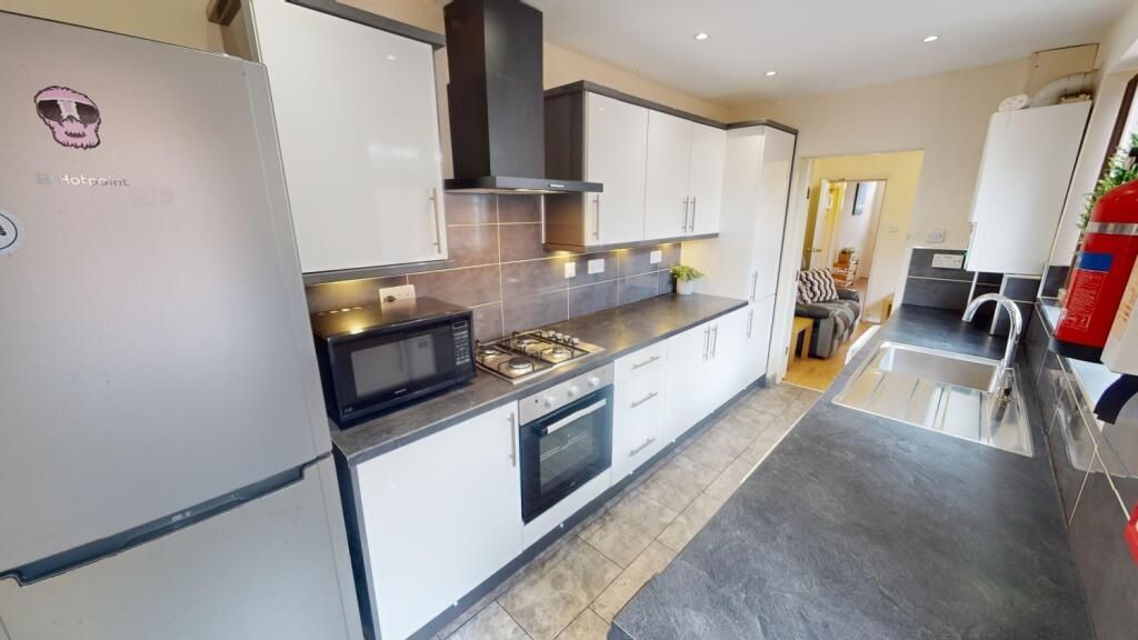 Property photo 2 of 7 Bright And Modern Kitchen Featuring Sleek White Ca...