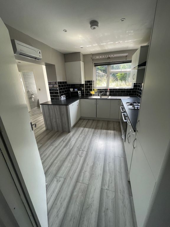 Property photo 3 of 12 Bright And Modern Kitchen Featuring Sleek White Ca...