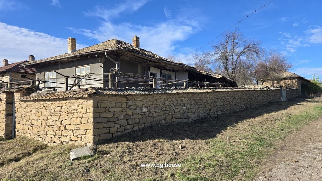 Property photo 1 of 51 Stone Wall Enclosing A Traditional Bulgarian House With Tiled Roof And Chimney Under Clear Blue Sky