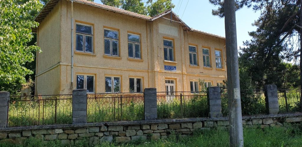Property photo 1 of 94 Exterior View Of The Two-Storey Former School Building With Yellow Walls And Many Windows, Set Behind A Stone And Metal Fence With Overgrown Grass