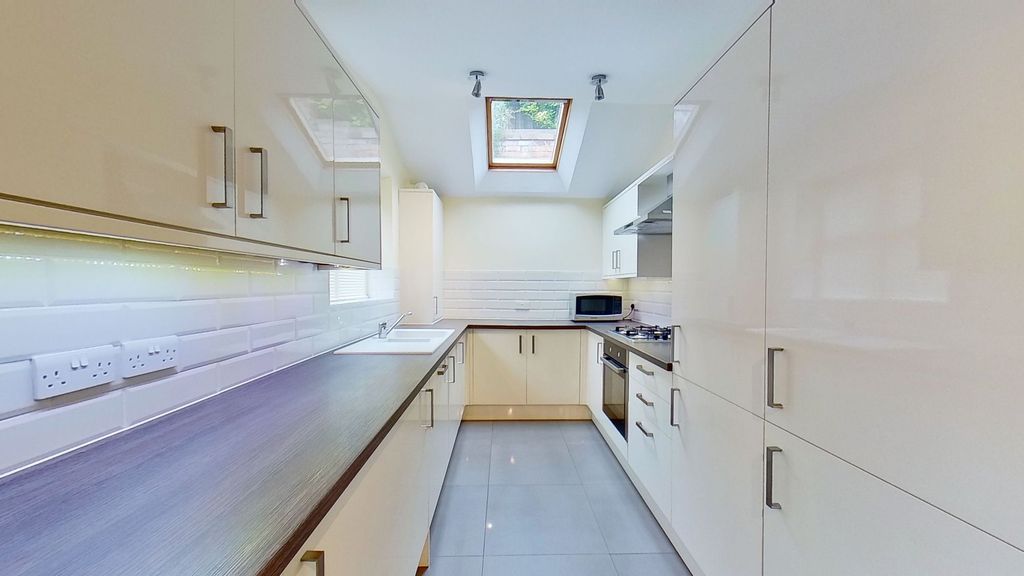 Property photo 3 of 9 Bright, Modern Galley Kitchen With Glossy Cream Ca...
