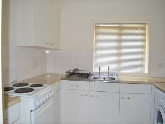 Property photo 3 of 5 Bright And Functional Kitchen Featuring White Cabi...