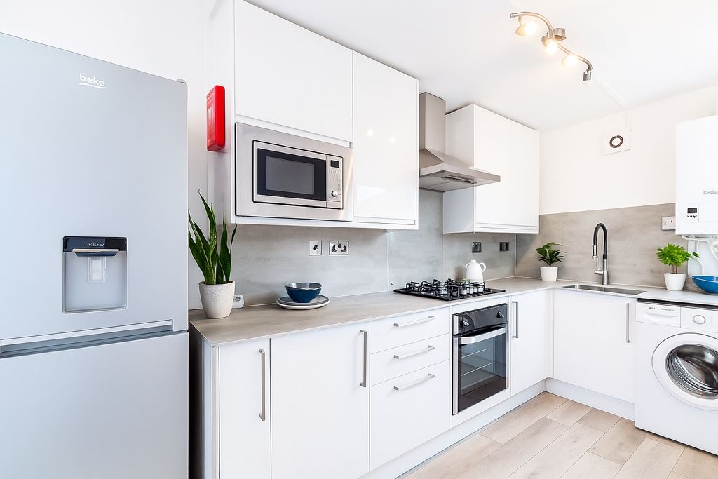 Property photo 1 of 6 A Modern, Sleek Kitchen Featuring White Cabinetry,...