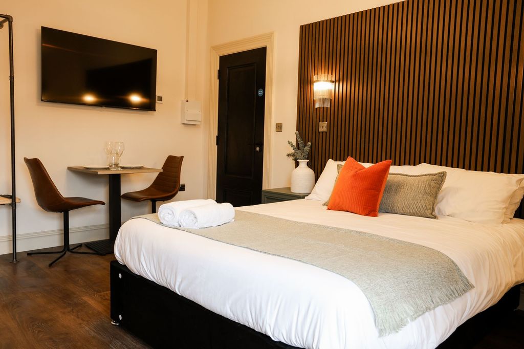 Property photo 2 of 9 Sleek Bedroom With Feature Wall And Dining Area...