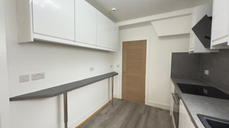 Property photo 3 of 4 Modern Kitchen With Sleek White Cabinets And Dark ...