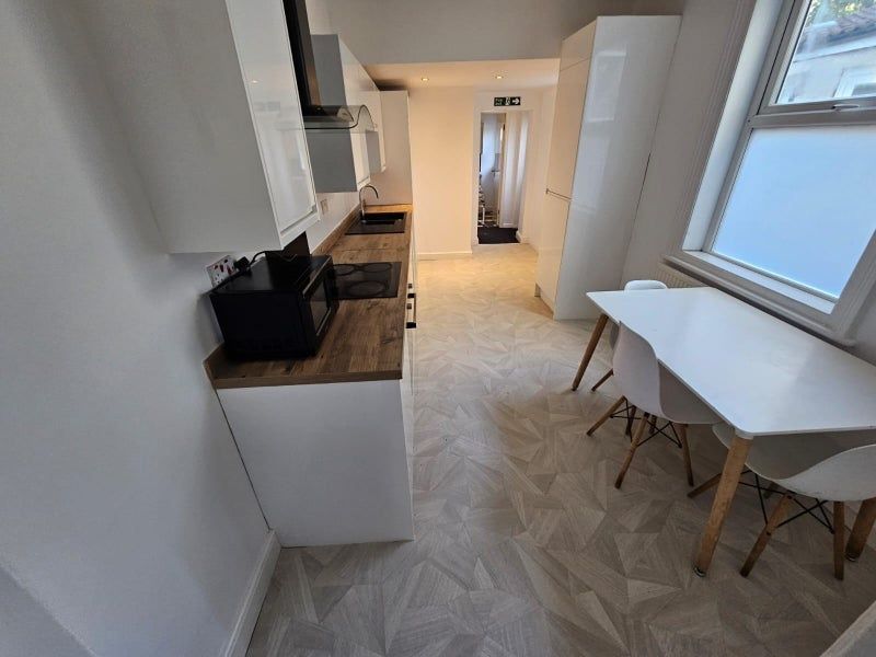 Property photo 3 of 14 Bright And Modern Kitchen Featuring Sleek White Ca...