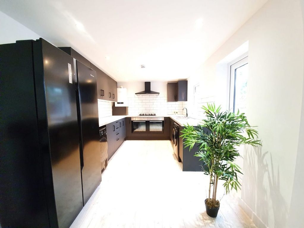Property photo 2 of 4 A Spacious And Modern Kitchen Featuring Sleek Blac...