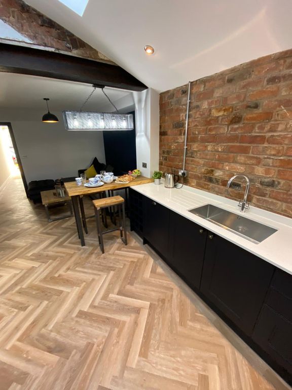 Property photo 3 of 6 Modern Kitchen Featuring Sleek Black Cabinetry, A ...