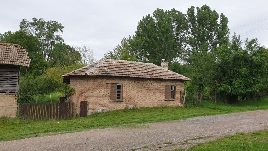 Property photo 1 of 50 View Of The Small Brick House With Tiled Roof And Wooden Shutters Surrounded By Greenery