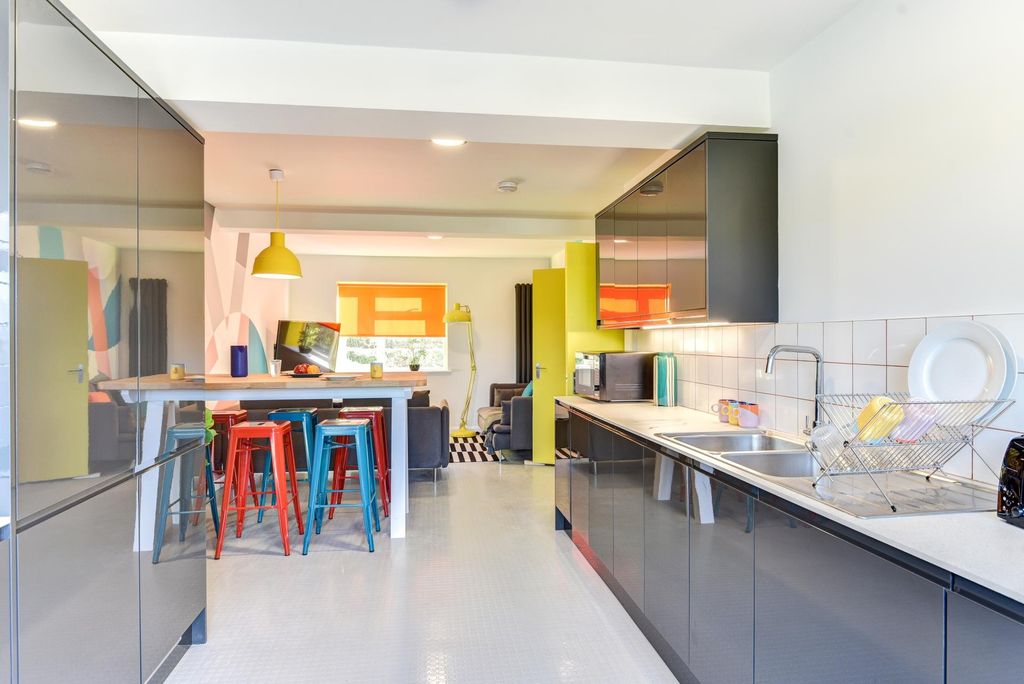 Property photo 1 of 6 Modern Kitchen Featuring Sleek Black Cabinetry, Am...