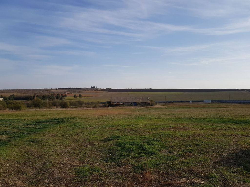 Property photo 3 of 33 Expansive Grassy Field With The Farm Building Visible Far Away, Under A Clear Blue Sky.