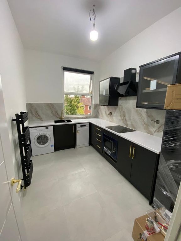 Property photo 2 of 9 Modern, Well-Lit Kitchen Featuring Sleek Black Cab...