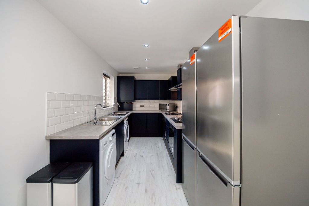 Property photo 1 of 6 Modern Kitchen Featuring Sleek Black Cabinetry, A ...