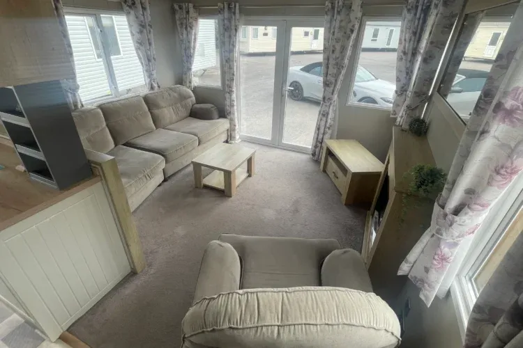Property photo 2 of 10 A Beige Living Room In A Caravan Or Lodge With A Sofa, Chair, Coffee Table, And TV On A Cabinet