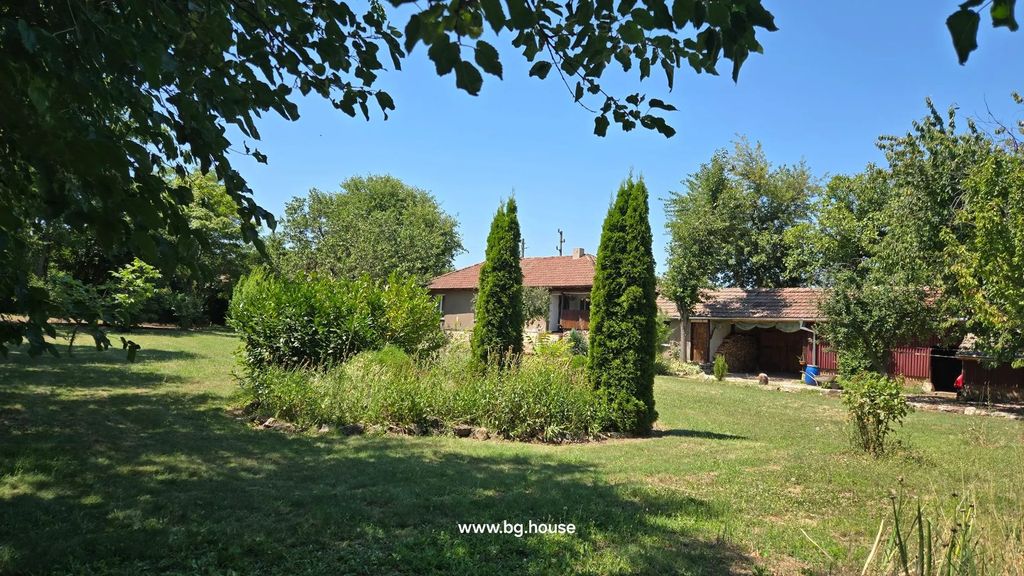 Property photo 3 of 79 View Of A Garden With Various Trees And Shrubs, And A House With A Tiled Roof In The Background Under A Clear Blue Sky.