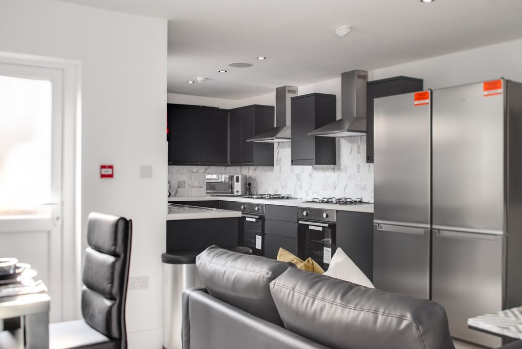 Property photo 2 of 11 Modern And Sleek Kitchen Featuring Dark Cabinetry,...